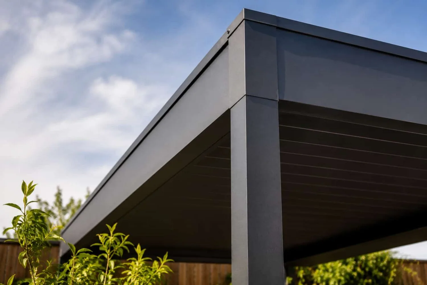 Close up of a powder coated aluminum hardtop gazebo frame against a blue sky showing solid construction and clean modern lines.