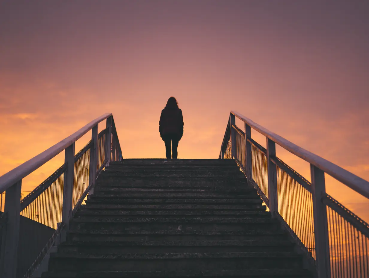 I feel like a failure. Woman standing at the top of stairs staring out into the sunset. 